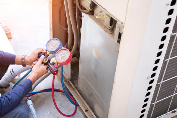 image of an hvac contractor checking ac refrigerant levels
