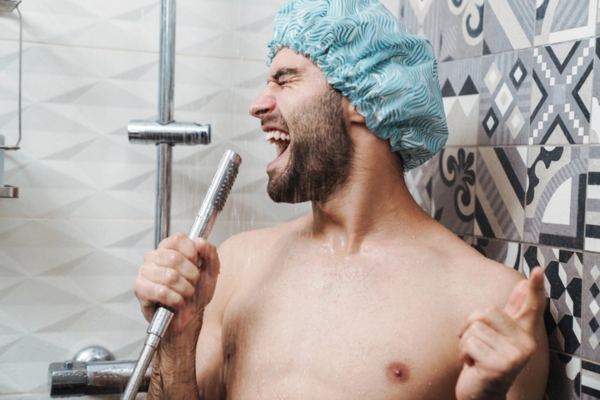 man singing while taking a shower to keep cool while waiting for air conditioner repair