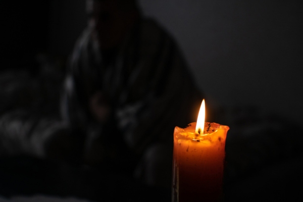 candle and man in a warm blanket in the background depicting generator won't start