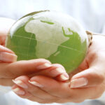 image of hands and earth depicting how to reduce carbon emissions