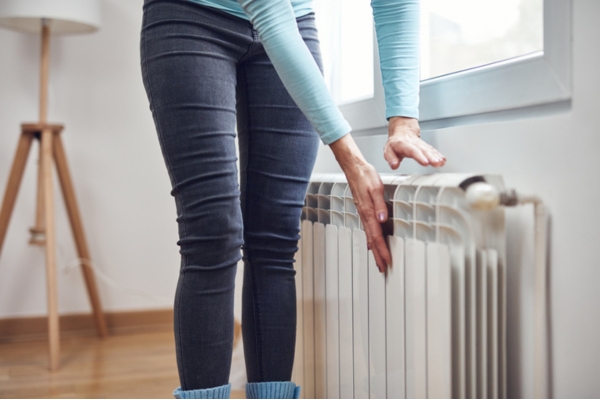 cropped view of a woman checking home radiator