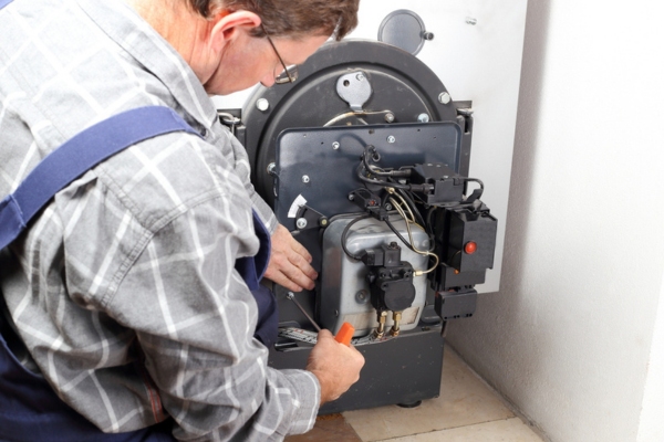 image of a man working on an oil burner